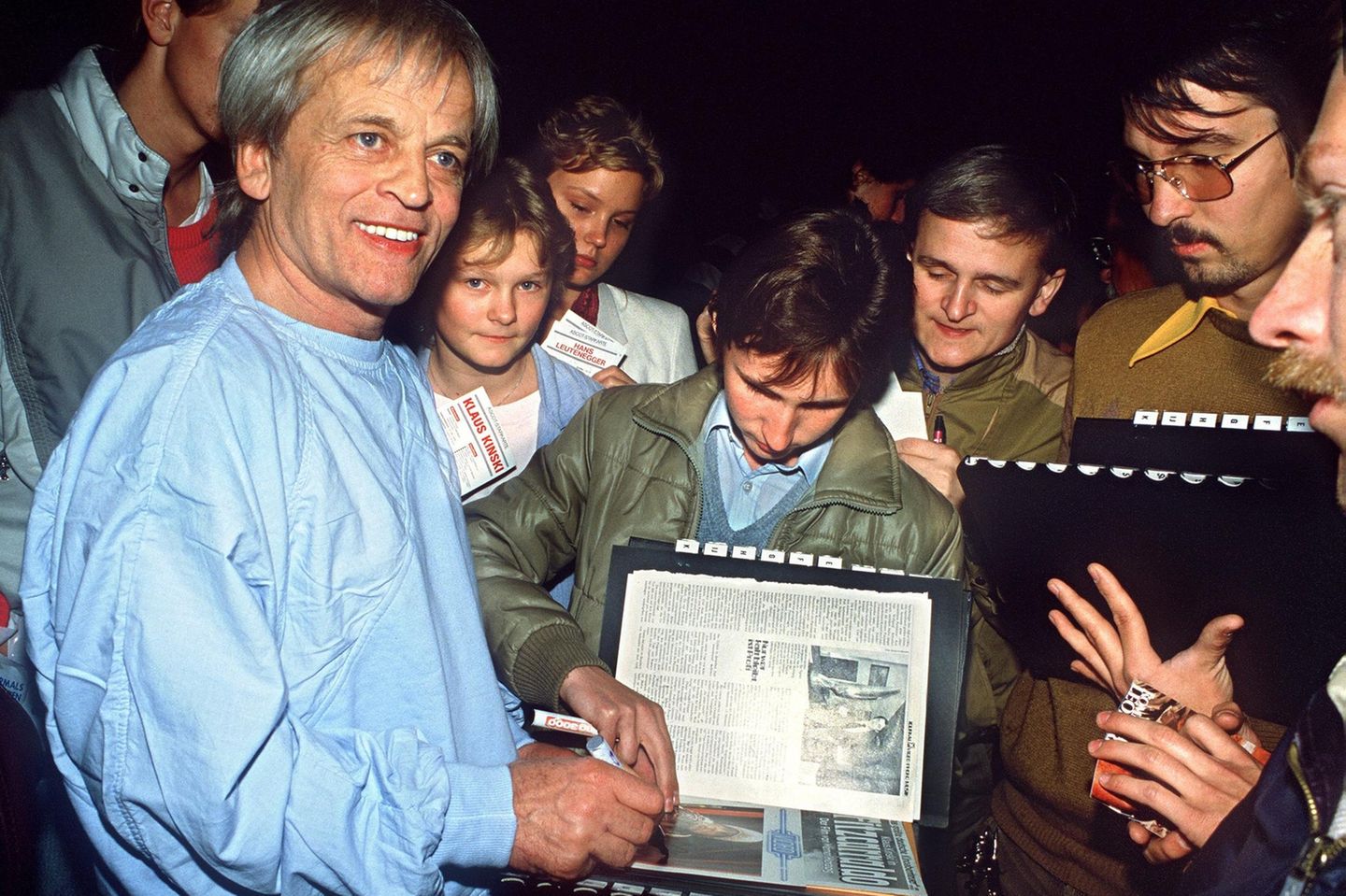 Klaus Kinski schreibt Autogramme