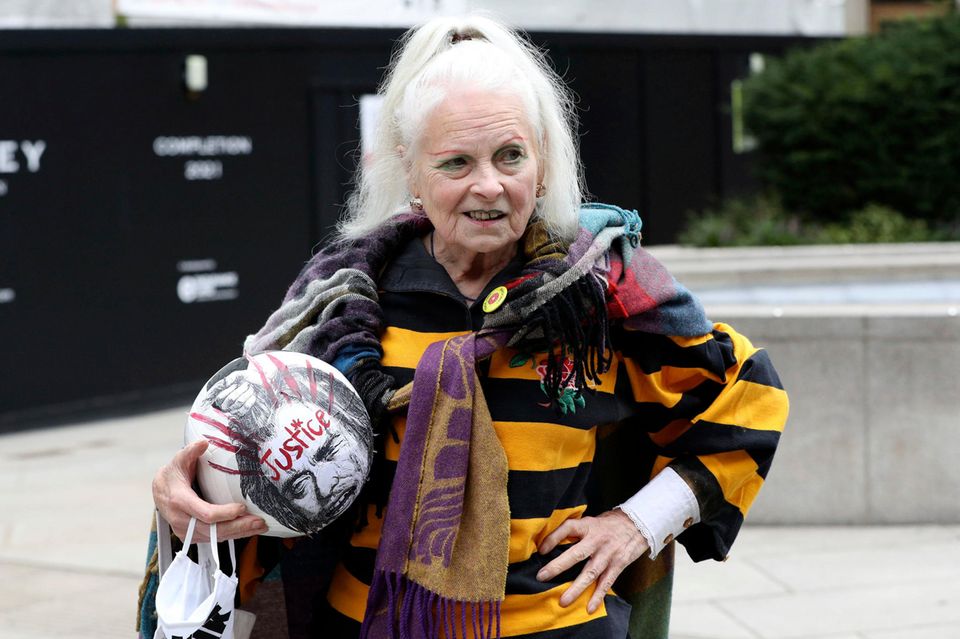 British designer Vivienne Westwood holds a ball with the writing Justice on it as she arrives at a London Court ahead of a hearing on the extradition to the United States of Wikileaks founder Julian Assange, in London, Monday, Sept. 7, 2020. Lawyers