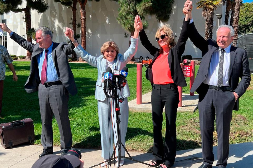 Attorneys John West, from left, Gloria Allred, plaintiff Judy Huth and attorney Nathan Goldberg join arms following a verdict i…
