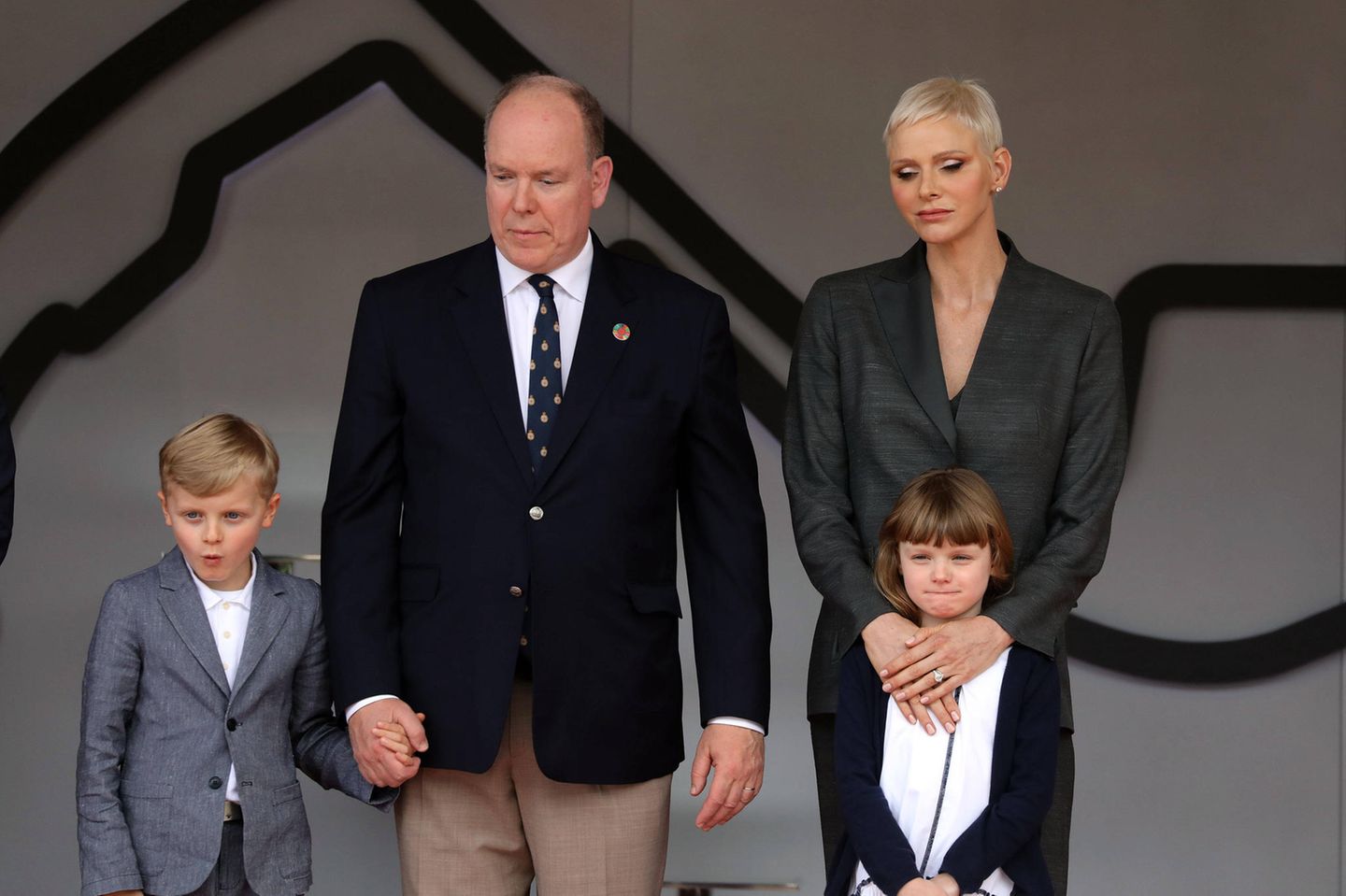 Jacques von Monaco, Fürst Albert, Fürstin Charlène und Gabriella stehen nebeneinander und schauen unzufrieden.