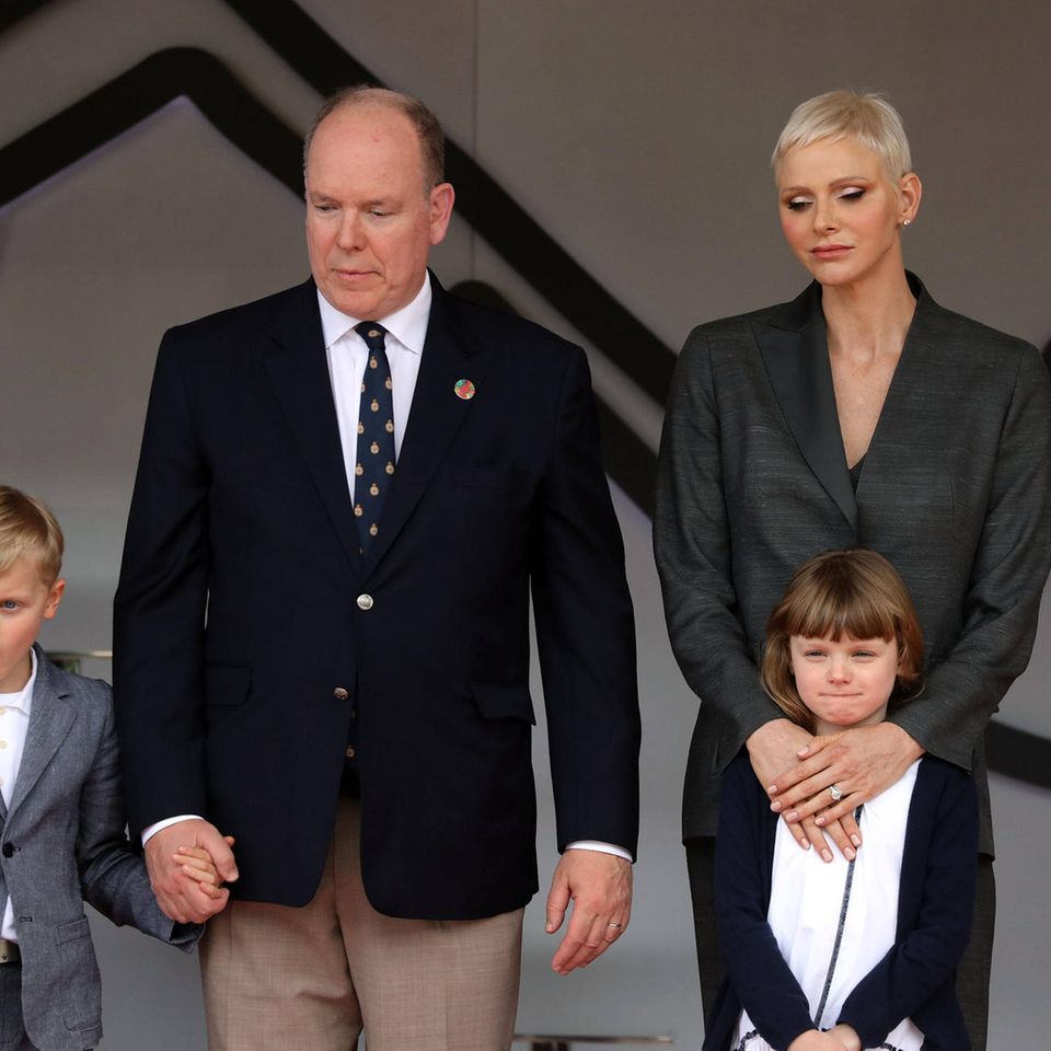 Jacques von Monaco, Fürst Albert, Fürstin Charlène und Gabriella stehen nebeneinander und schauen unzufrieden.