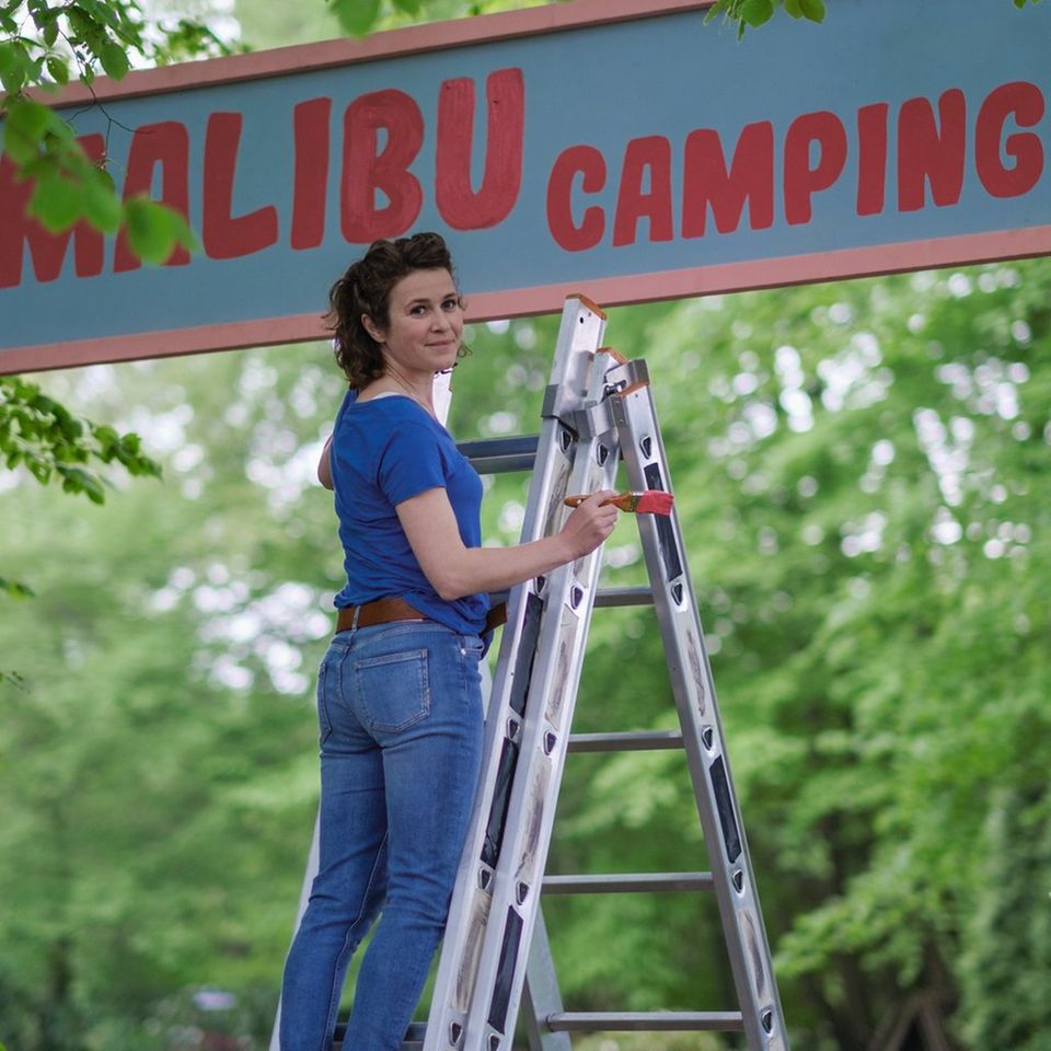 "Malibu: Ein Zelt für drei": Jantje (Karla Nina Diedrich) verpasst dem Eingang von "Malibu Camping" einen neuen Anstrich.
