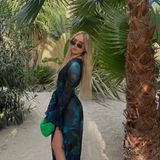 In Saint-Tropez wählt Shania Geiss einen aufregenden Strandbar-Look. Ein lockeres Kleid mit Rüschen und Schlitz kombiniert sie zur Sonnenbrille im Cateye-Stil, das Haar trägt sie unaufgeregt offen. Ein teures Detail entpuppt sich durch das klassische Design sofort: Ihre grüne Designer-Handtasche von Bottega Veneta.