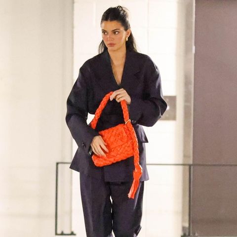 Bloß nicht auffallen? Das hat sich Kendall Jenner mit der Tasche garantiert nicht gedacht. Sie kombiniert das neonorangefarbene Statement-Piece zum dunkelblauen Anzug. Hammer Look!