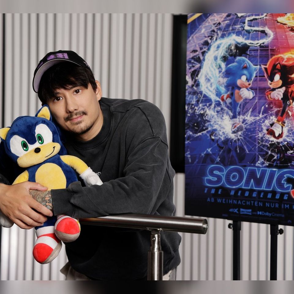 Julien Bam hält den blauen Igel Sonic im Arm, dem er seine prominente Stimme leiht.