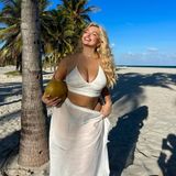 Strahlend blauer Himmel, weißer Sandstrand und frische Kokosnüsse: Sarina Nowak lässt es sich in ihrem Urlaub derzeit so richtig gut gehen. Für einen von der Sonne geküssten Teint gibt das Model in seinem weißen, tief ausgeschnittenen Top und dem passenden Sarong alles. Das Gesicht reckt Sarina dabei ganz natürlich gen Sonne, wodurch sie noch mehr strahlt als ohnehin schon. 